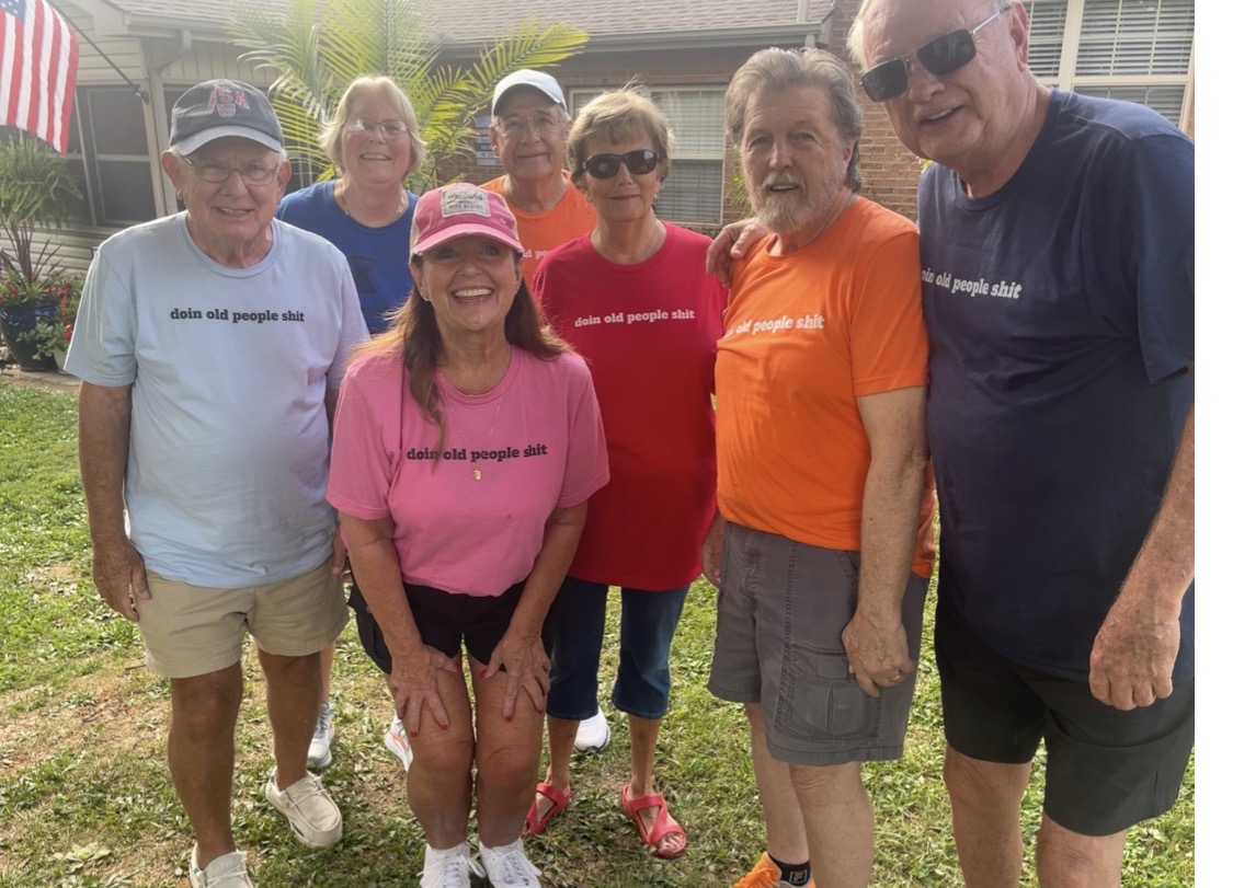Group of friends in the backyard wearing DOPS.LIFE “doin old people shit” tees in pink, red, orange, blue and navy